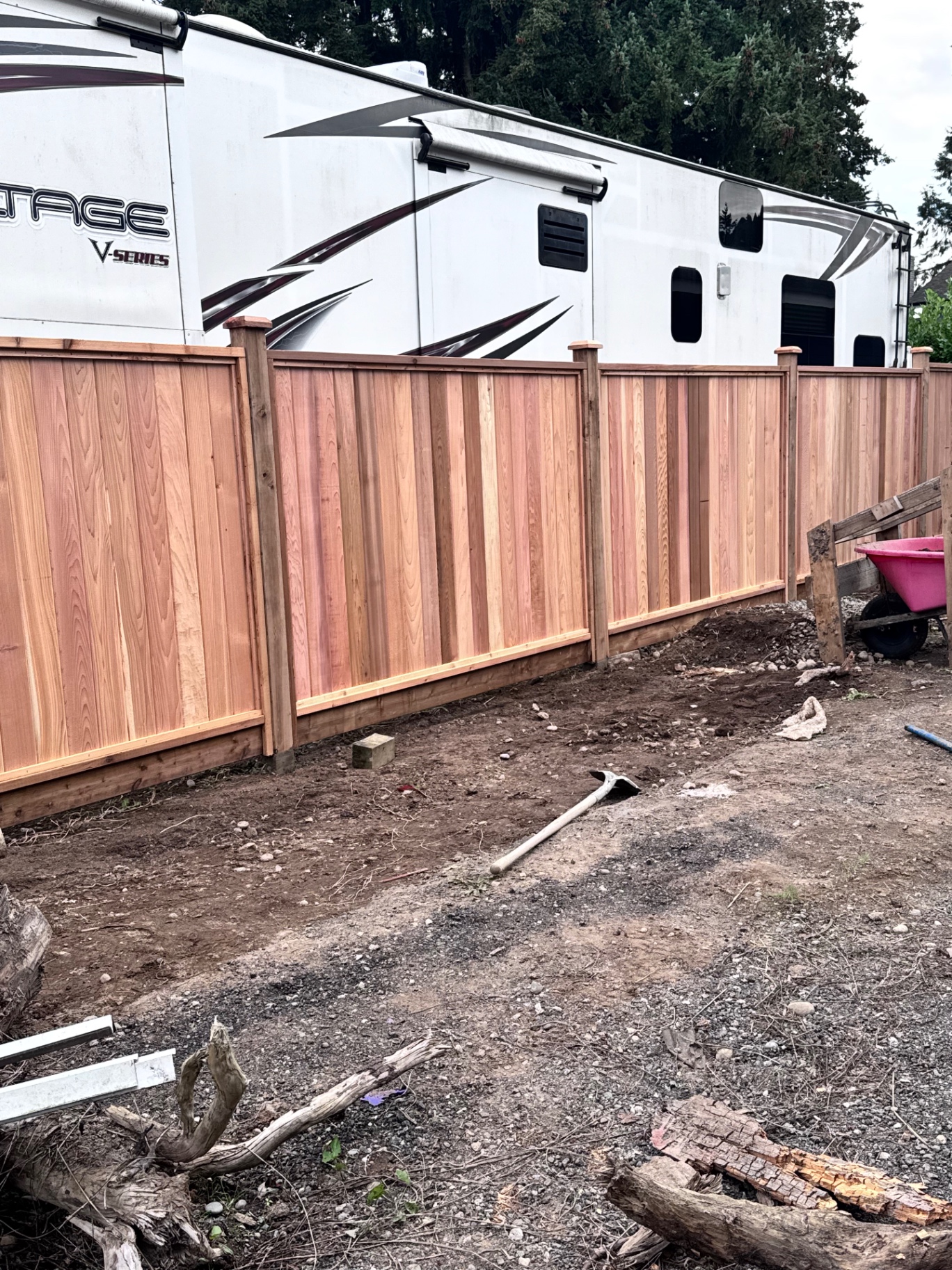 Tall cedar privacy fence screening an RV parking pad